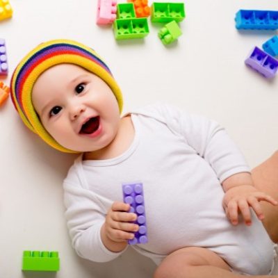 baby-boy-playing-with-multi-colored-constructor-white-wall_98296-1967